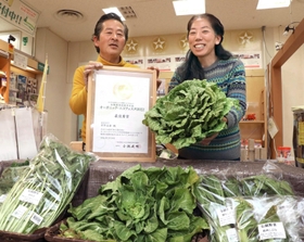 栽培した有機野菜や賞状を手にする岡野圭佑さん（左）と美代子さん夫婦＝神戸市中央区御幸通８