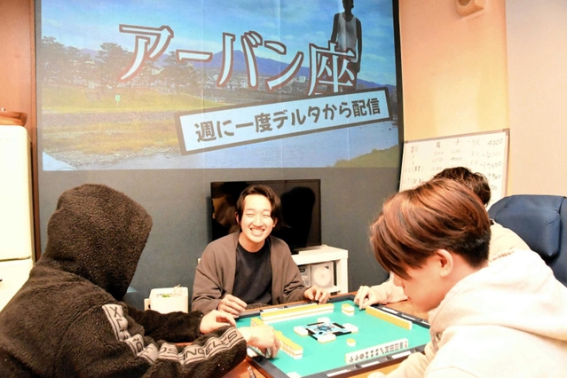 友人と共同生活を送る吉岡さん（中央）。背景の画面はユーチューブチャンネル＝多可町加美区門村