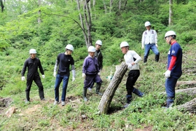 重い丸太を運び出す「雷神ファクトリー」のメンバーら＝加西市上万願寺町