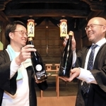 日本酒「朔」の瓶を手に、住吉神社で豊作を願う庄司英生さん（左）と稲岡敬之さん＝加西市北条町北条