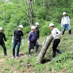 重い丸太を運び出す「雷神ファクトリー」のメンバーら＝加西市上万願寺町