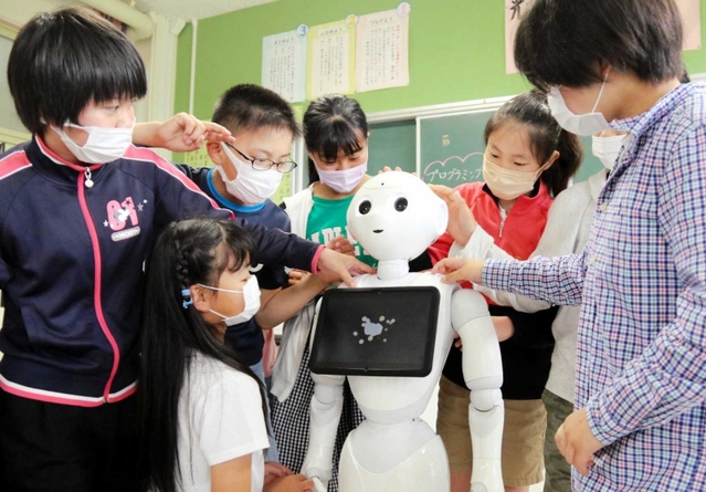 授業後にペッパーと触れ合う児童たち＝加東市上久米