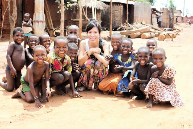 ２０１５年のベナン滞在中、子どもたちと記念撮影するエケ陽子さん（中央）＝本人提供