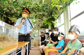 スパイシー八木さん（左）からカブトムシの豆知識を聞く参加者＝小野市内