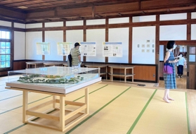 同校の記念室で学校の歴史を学ぶ見学者ら＝西脇市西脇