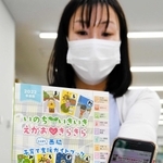西脇市が製作した子育て支援のガイドブックとアプリ画面＝同市役所