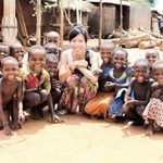 ２０１５年のベナン滞在中、子どもたちと記念撮影するエケ陽子さん（中央）＝本人提供