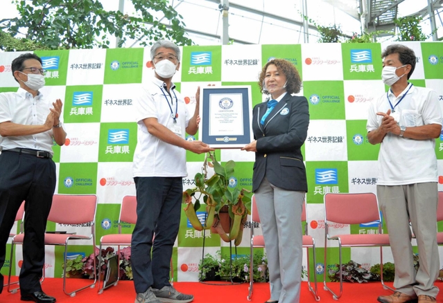 ギネス世界記録の公式認定証を受け取る石田均園長（左から２人目）と栽培担当の土居寛文さん（右端）＝県立フラワーセンター
