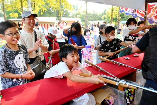 露店の射的を楽しむ家族＝西脇市上比延町