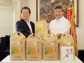 贈呈式でマスクを外し、記念撮影に応じる若浦直樹校長（右）と神澤友重組合長＝社高校