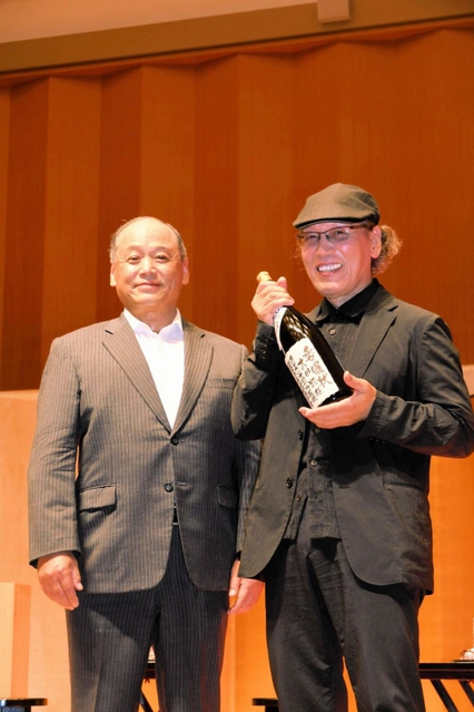 岩根正市長から委嘱状代わりの一升びんを受け取る吉田さん＝加東市上三草