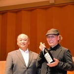 岩根正市長から委嘱状代わりの一升びんを受け取る吉田さん＝加東市上三草