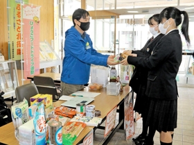 フードドライブ窓口で菓子などを託す社高校の生徒＝加東市社