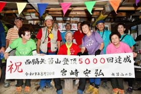 矢筈山への登頂５千回を達成し、仲間から祝福される宮崎安弘さん（中央）＝西脇市谷町