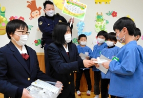 ２年間育てたヒマワリの種を園児に手渡す播磨農業高校生ら＝加西市中野町
