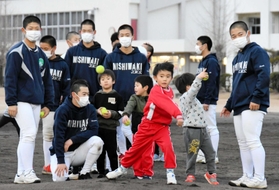 高校球児に見守られながらテニスボールを投げる子ども＝西脇市野村町