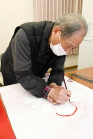 年間６０枚以上の垂れ幕を手描きする園崎孝さん＝多可町