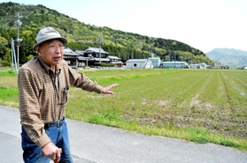 戦闘機「紫電」の墜落場所を指さす藤本幸三さん＝多可町中区森本