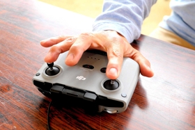 両手で操作するコントローラーを、片手で器用に使う＝三木市内