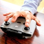 両手で操作するコントローラーを、片手で器用に使う＝三木市内