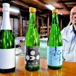 世界的なワイン品評会で入賞した（左から）「祝泡」「特別純米　山田錦」「純青」。奥は稲岡敬之社長＝加西市三口町、富久錦