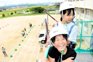 高所作業車で笑顔を見せる児童＝大部小学校