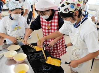 だし巻き卵を作る児童たち＝泉小学校