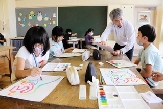 大西久教授（右から２人目）に教わりながら自由に色を描く児童＝社小学校