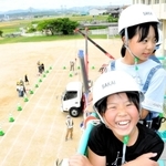 高所作業車で笑顔を見せる児童＝大部小学校
