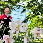 種から育て、２年連続で開花したササユリと辻本晋さん＝小野市葉多町