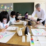 大西久教授（右から２人目）に教わりながら自由に色を描く児童＝社小学校