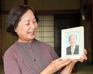 高橋大和投手の活躍を願い、修一さんの遺影を持つ千里さん＝加東市野村