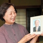 高橋大和投手の活躍を願い、修一さんの遺影を持つ千里さん＝加東市野村