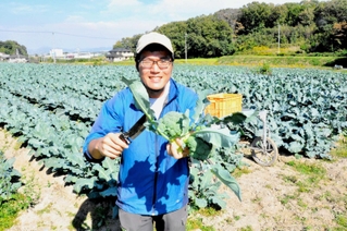 収穫したブロッコリーを持つ池田陽さん＝小野市阿形町