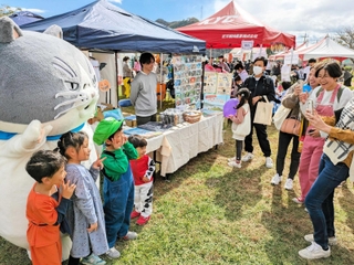 マルと記念撮影する親子連れ＝西脇市野村町、茜が丘複合施設みらいえ
