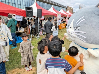 会場に登場したマルにタッチする子どもたち＝西脇市野村町、茜が丘複合施設みらいえ