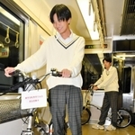 実証実験で、電車内に自転車を持ち込む男子高校生＝西脇市内