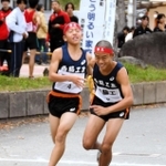 男子・西脇工の４区佐伯優月選手（左）が、５区赤坂勇輔選手にたすきをつなぐ＝西脇市総合市民センター