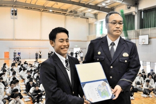 全校生約４３０人の前でのじぎく賞を受けた西田悠生さん（左）と大戸英治署長＝小野工業高校