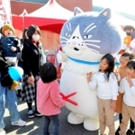 マルと記念撮影する子どもたち＝オリナス駐車場