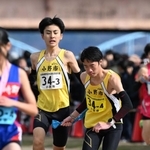 男子・小野市の３区渡辺裕珂選手（左）からたすきを受ける４区森本健斗選手＝加古川河川敷マラソンコース（撮影・風斗雅博）
