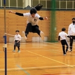 ゴムひもを跳んだりまたいだりして運動する子どもたち＝滝野体育センター