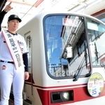 進行方向を指す東晃平投手。電車のヘッドマークには東投手がデザインされている＝神鉄小野駅
