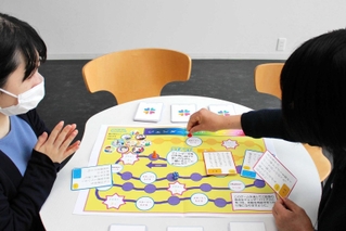 ボードゲームを体験する加東市の担当者ら＝加東市役所