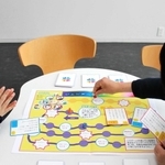 ボードゲームを体験する加東市の担当者ら＝加東市役所