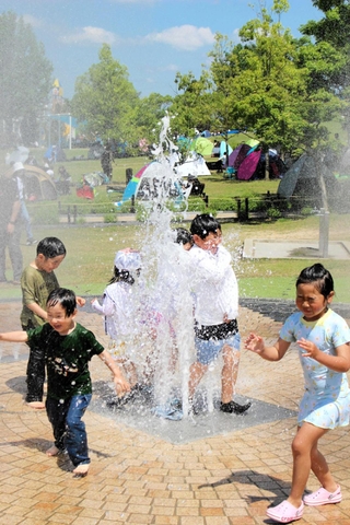 噴水で水遊びを楽しむ子どもたち＝ひまわりの丘公園