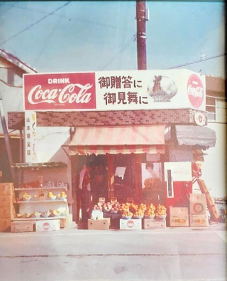 道路反対側の角地にあった旧店舗。約１０平方メートルの広さから始まった（山本喜隆さん提供）