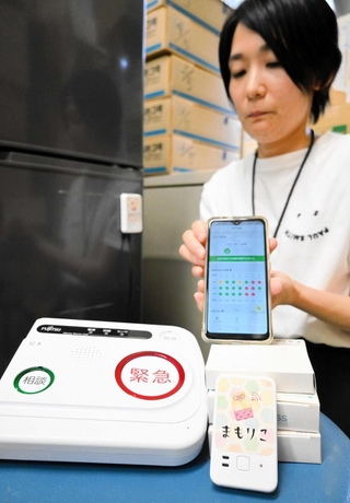冷蔵庫に貼り付けて使う「まもりこ」の端末（手前右）。左は緊急通報システムの通報装置＝加西市役所