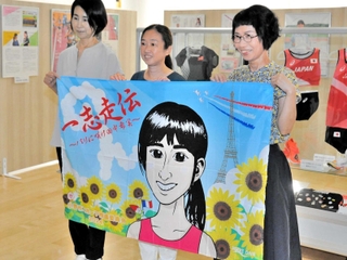 田中希実選手の応援旗を手にする（右から）田中博美さん、田中千洋さん、石井奈津子さん＝小野市役所