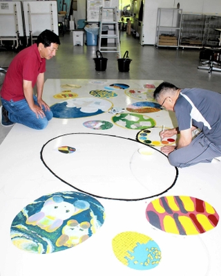 壁画の制作を見守る谷口文保さん（左）＝神戸芸術工科大学